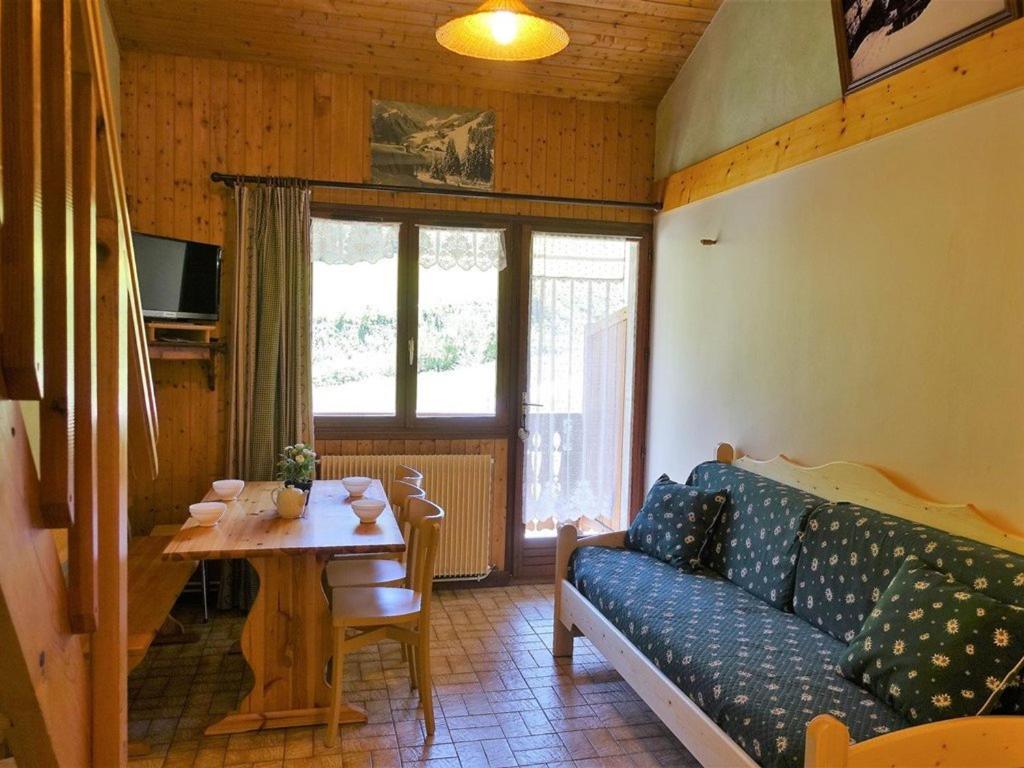 Una sala de estar con un sofá azul y una mesa. en Appartement 4-5 pers. à Arêches-Beaufort - Pied des Pistes, Balcon Sud, Parking, Casier à Skis - FR-1-342-134, en Arêches