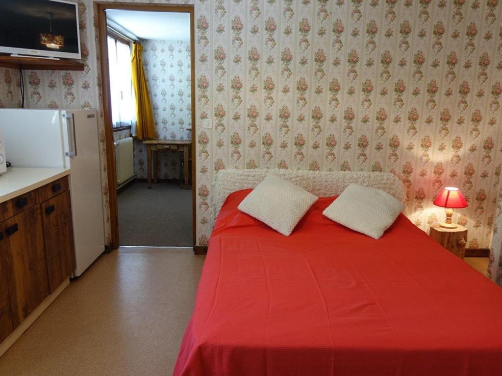 ein rotes Bett mit zwei Kissen in einem Zimmer in der Unterkunft Appartement Arêches-Beaufort, 2 pièces, 5 personnes - FR-1-342-155 in Arêches