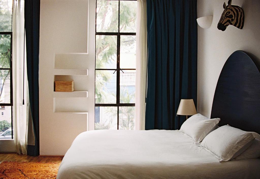 a bedroom with a bed and a large window at Casa Pani in Mexico City