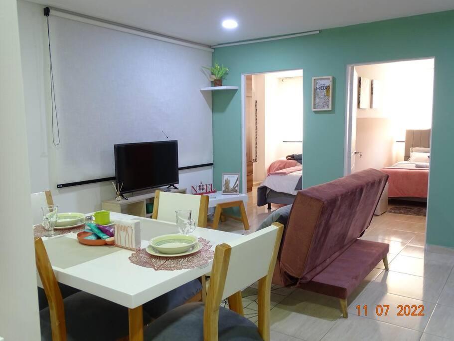 a living room with a table and chairs and a tv at Acogedor apartamento en Fusagasugá in Fusagasuga