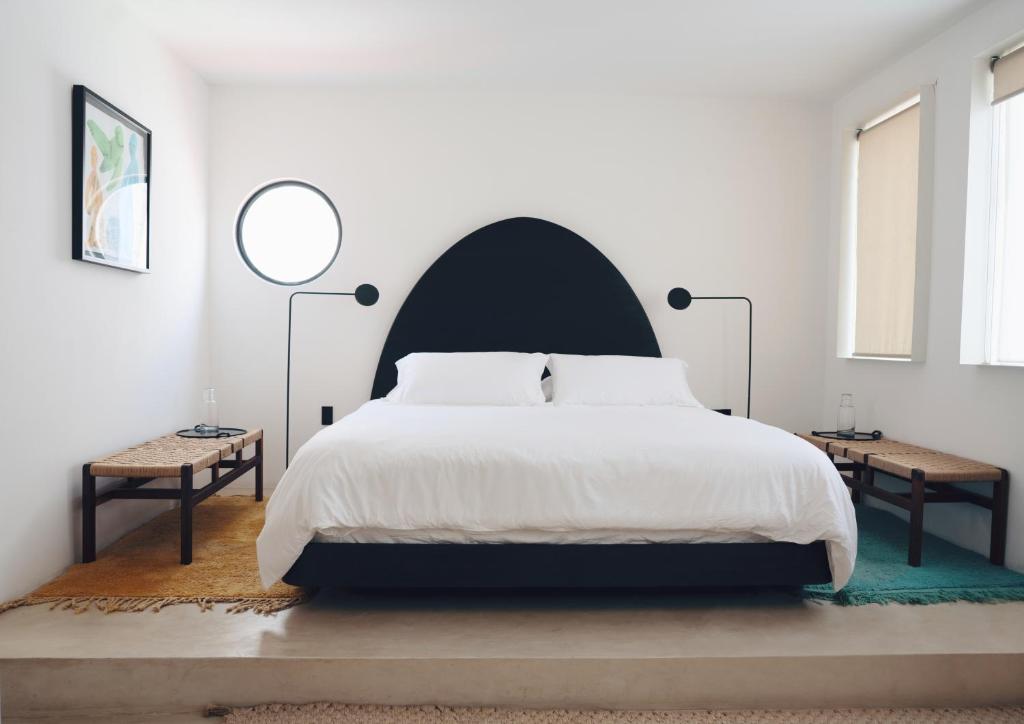 ein Schlafzimmer mit einem großen weißen Bett mit schwarzem Kopfteil in der Unterkunft Casa Pani in Mexiko-Stadt