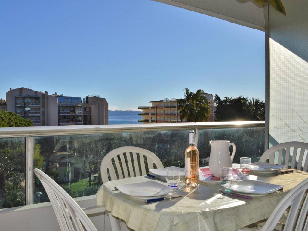 a table with white chairs and a table with a view at Appartement Le Lavandou, 2 pièces, 4 personnes - FR-1-251-297 in Le Lavandou