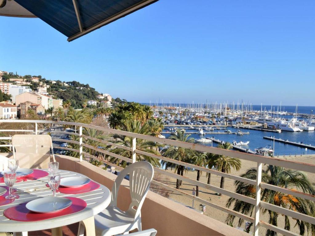 a balcony with a table and chairs and a marina at Appartement Le Lavandou, 2 pièces, 4 personnes - FR-1-251-287 in Le Lavandou