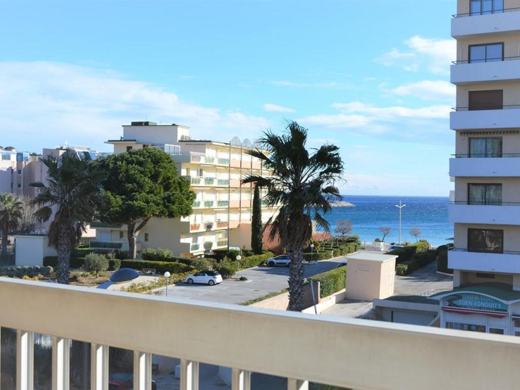 - un balcon avec vue sur l'océan et les bâtiments dans l'établissement Studio rénové avec terrasse, aperçu mer et parking privatif au Lavandou, 3 couchages - FR-1-251-303, au Lavandou