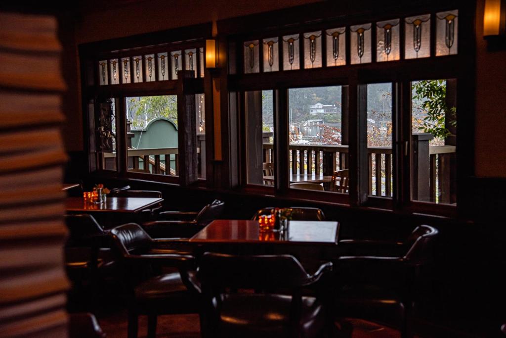a dining room with tables and chairs and windows at Salt Spring Inn in Ganges