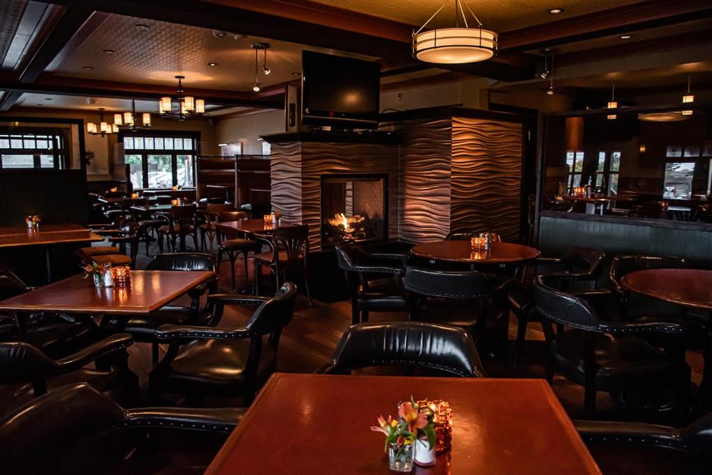 a restaurant with tables and chairs and a bar at Salt Spring Inn in Ganges