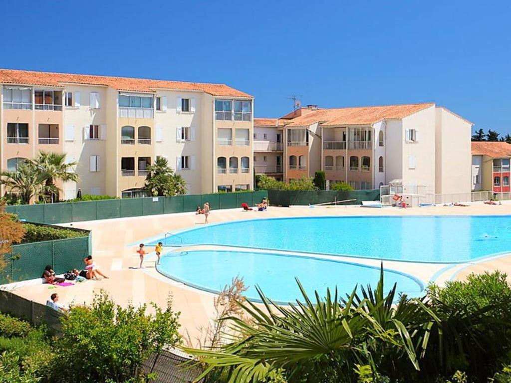 une grande piscine devant certains immeubles d'habitation dans l'établissement Appartement 2 pièces, 4 couchages avec piscine, proche commerces et théâtre romain à Fréjus - FR-1-226A-366, à Fréjus