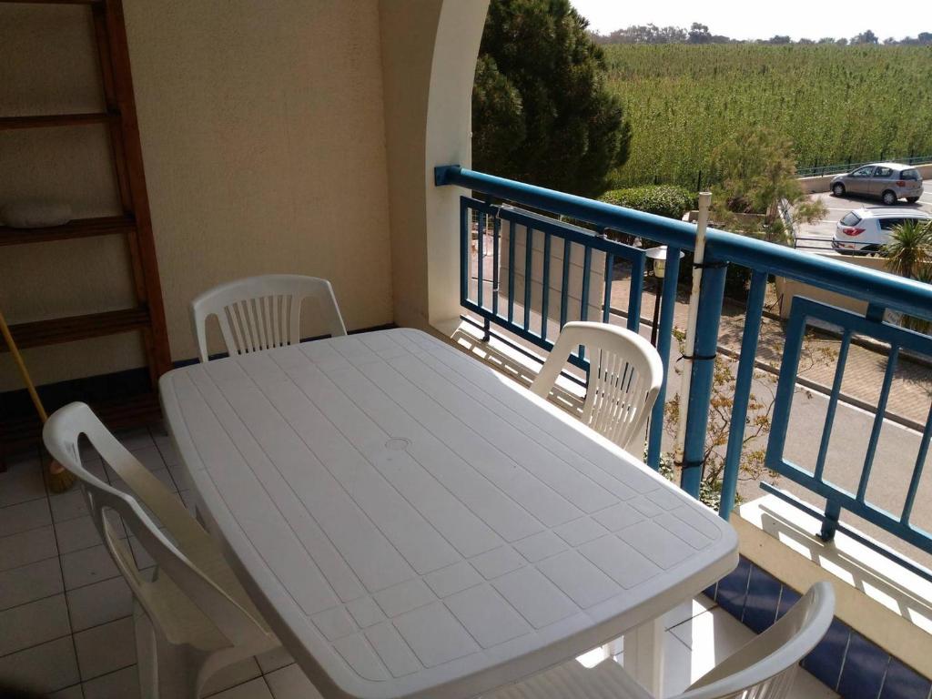 une table blanche et des chaises sur un balcon dans l'établissement Appartement 2 étoiles avec piscine, balcon, 2 chambres, proche plage - Le Lavandou - FR-1-308-92, au Lavandou