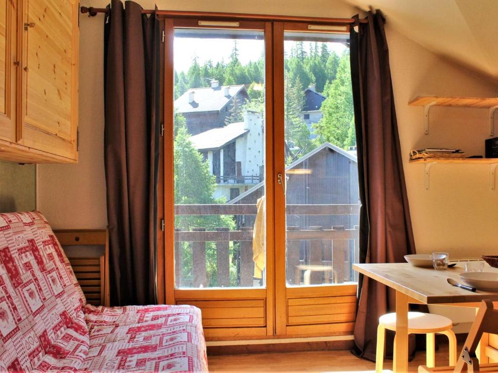 a living room with a large glass door with a table and a tableablish at Studio calme pied de pistes, 4 couchages, Risoul 1850 - FR-1-330-481 in Risoul
