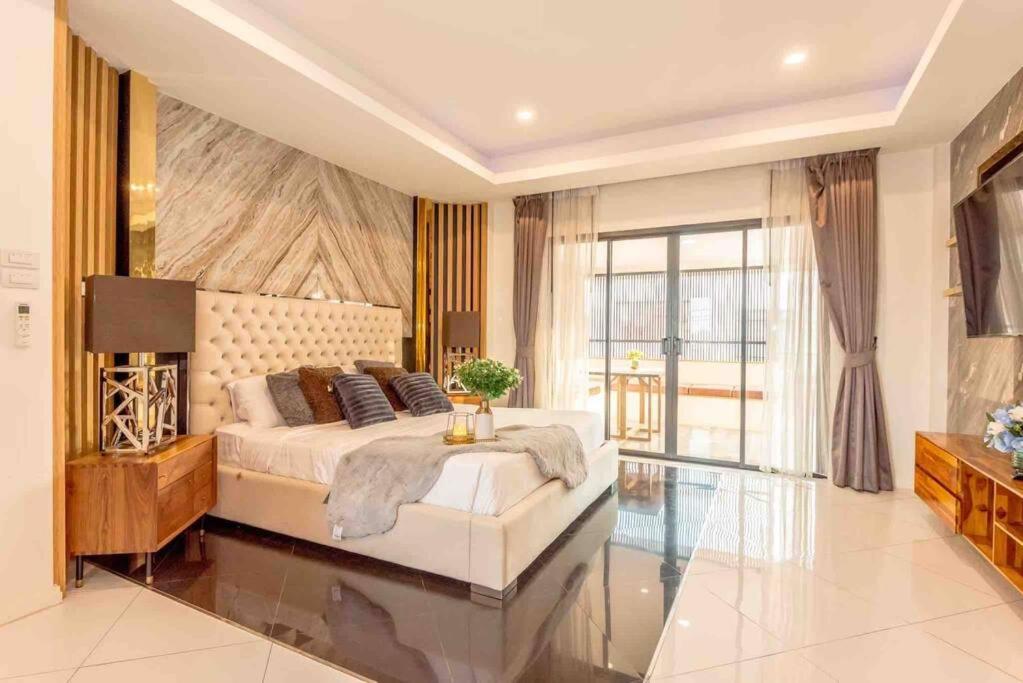 a large bedroom with a bed and a television at 3BD Pool Villa Pattaya with sauna - Exquisite Pool Villa B in Nong Prue