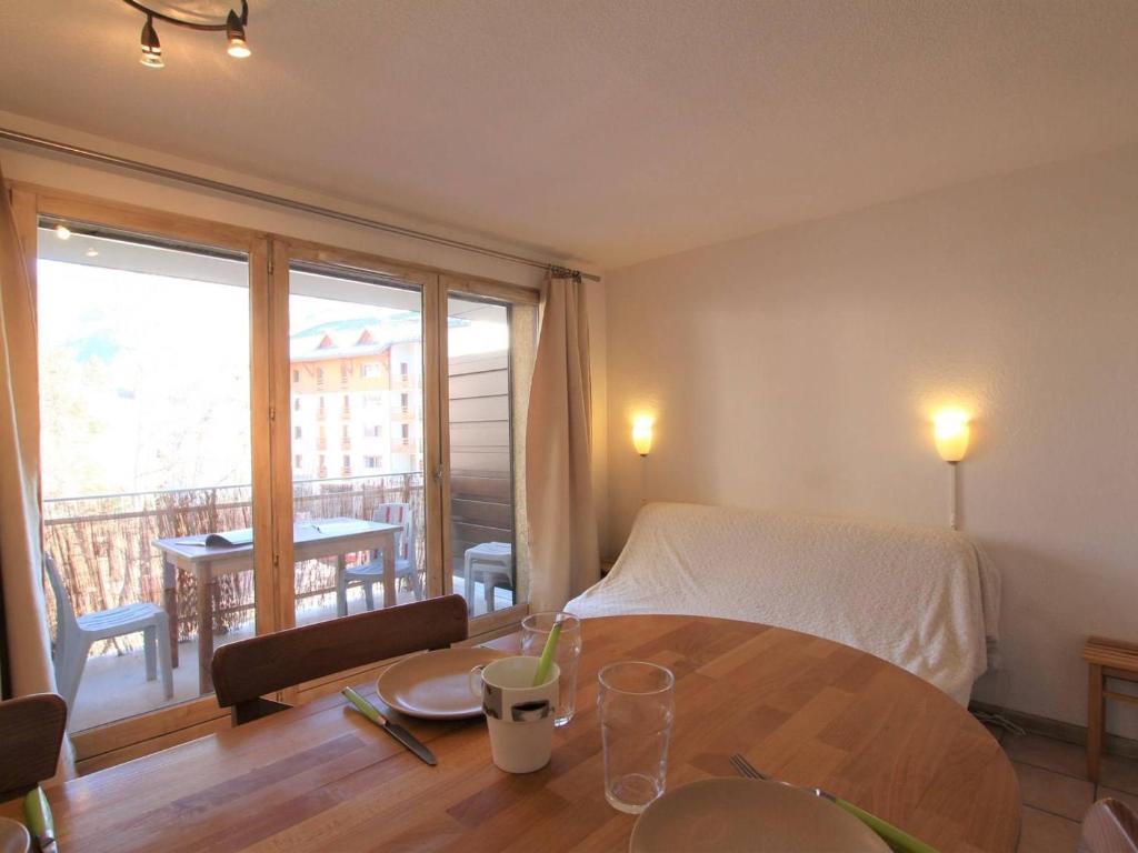 une chambre avec une table et un lit et un balcon dans l'établissement Studio 4 pers. à Briançon – Pied de pistes, proche commerces, balcon, parking privé - FR-1-330C-53, à Briançon