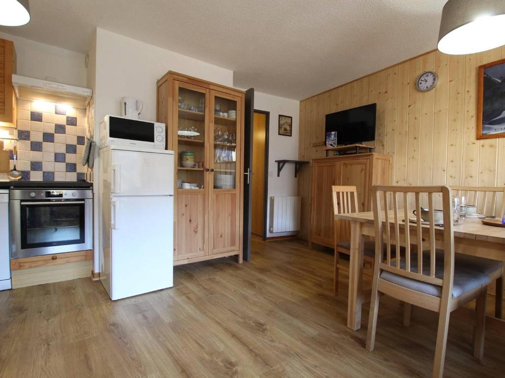 a kitchen with a table and a white refrigerator at Appartement Vallouise-La Casse, 2 pièces, 6 personnes - FR-1-330G-57 in Le Poët