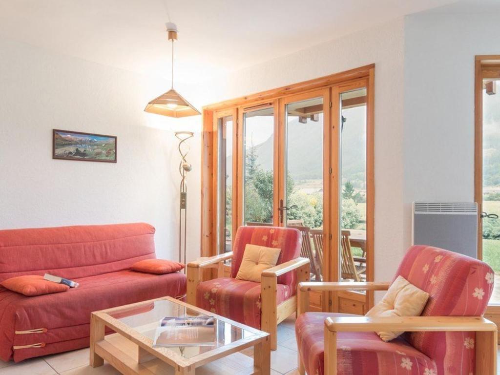 un salon avec un canapé rouge et deux chaises dans l'établissement Confortable appartement 4 pièces, terrasse, parking, proximité pistes et navettes - 6 couchages - FR-1-330F-135, au Monêtier-les-Bains