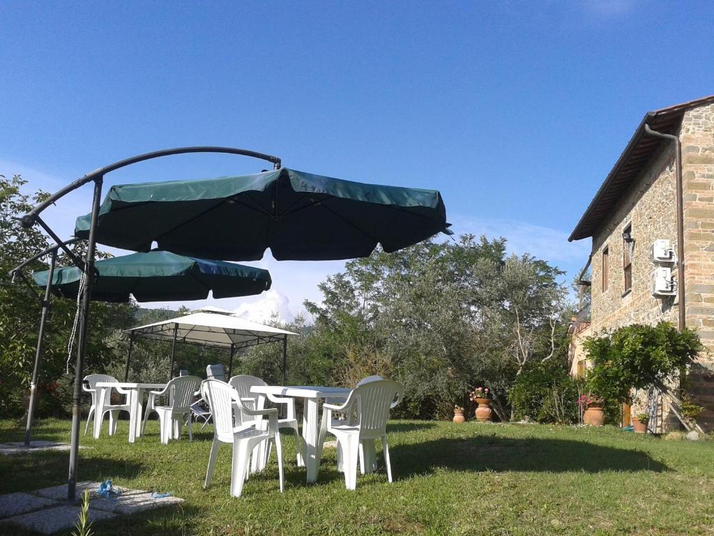 a group of tables and chairs under an umbrella at Le Mimose B&B in Vinci