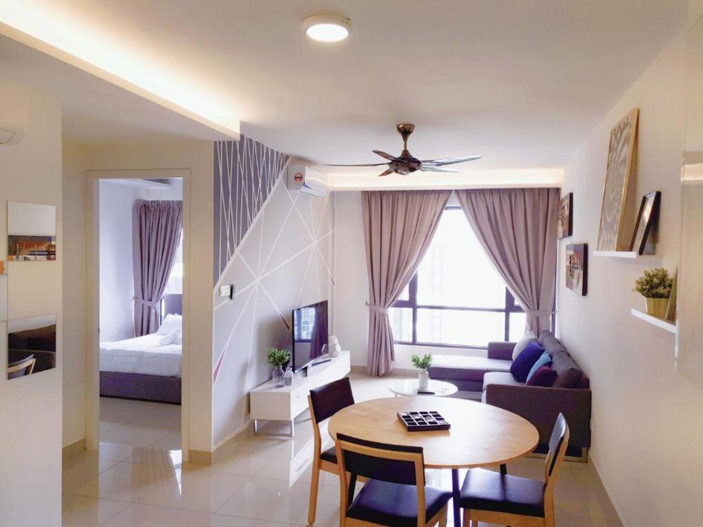 ein Wohnzimmer mit einem Tisch und ein Schlafzimmer in der Unterkunft Cyberjaya Eclipse 5 Plus 2 PAX Blissful Suite in Cyberjaya