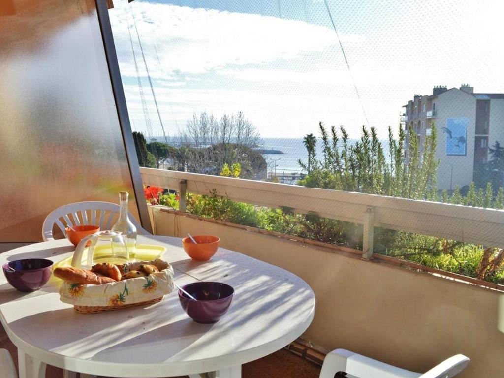 a table with a plate of food on a balcony at Le Lavandou : T2 avec 4 couchages, terrasse, parking en option, animaux admis - FR-1-251-212 in Le Lavandou