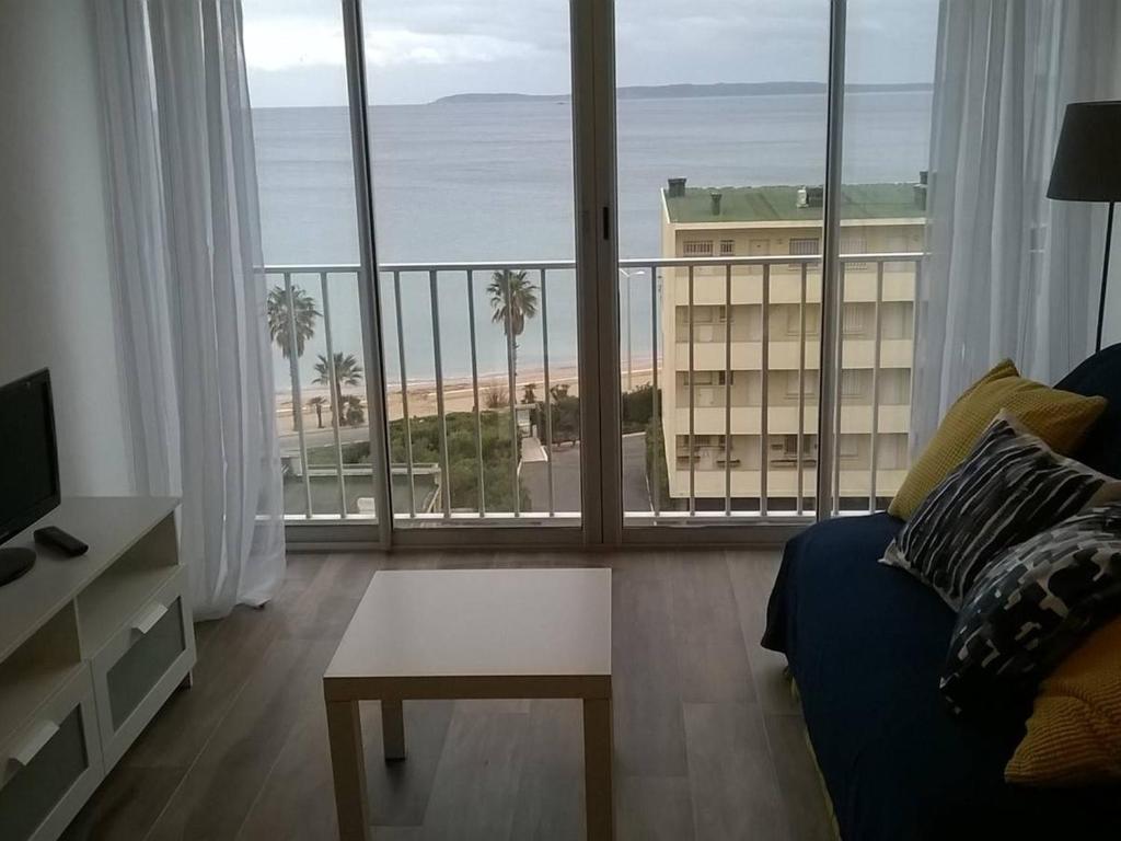 - un salon avec un canapé et une vue sur la plage dans l'établissement Studio Le Lavandou, 1 pièce, 2 personnes - FR-1-308-81, au Lavandou