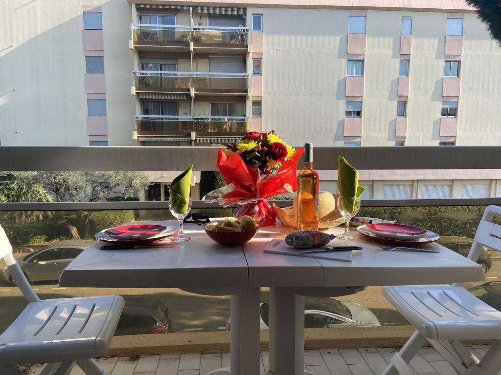 uma mesa com um ramo de flores numa varanda em Appartement Fréjus, 1 pièce, 2 personnes - FR-1-226A-356 em Fréjus
