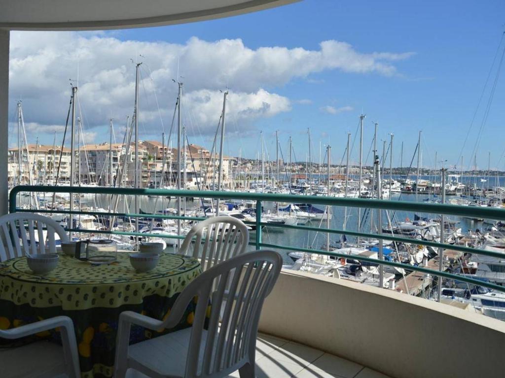 d'un balcon avec une table et des chaises ainsi qu'un port de plaisance. dans l'établissement Fréjus: Appt 2P, 5 pers, Piscine, Plage à 150m, Parking, Animaux OK - FR-1-226A-357, à Fréjus