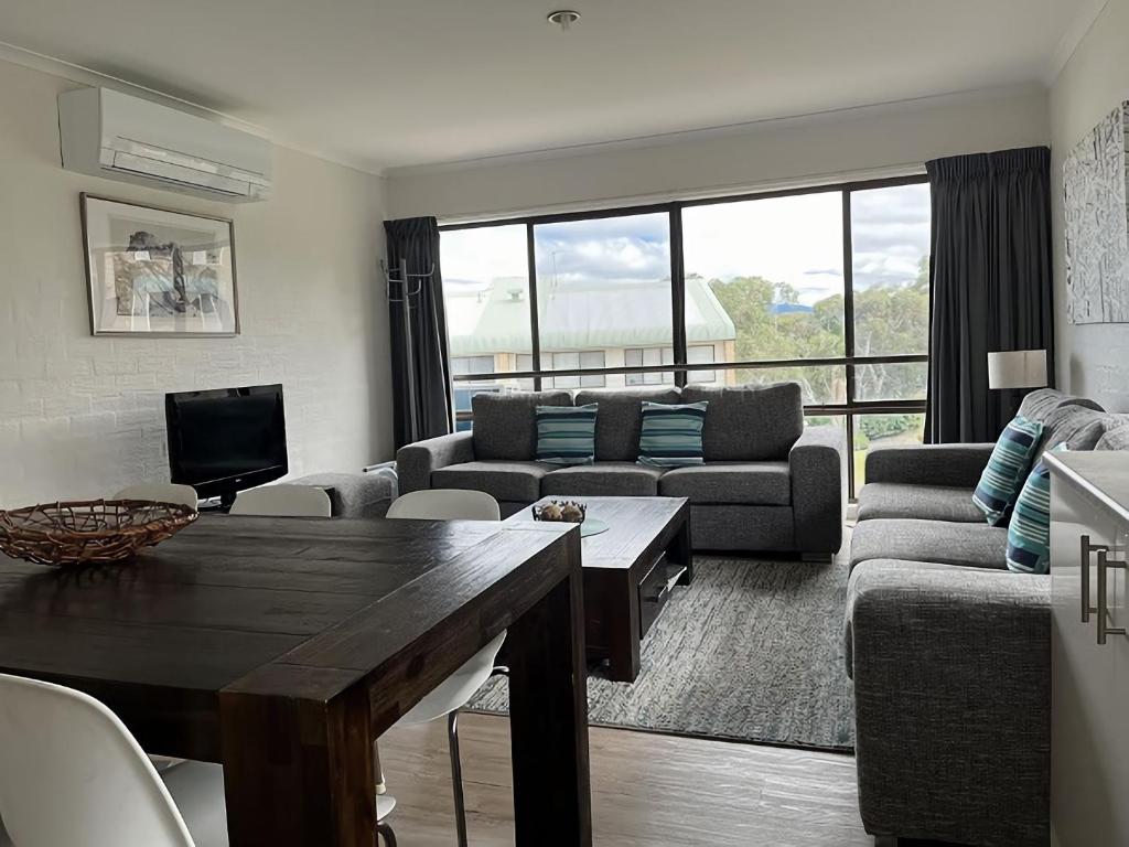 a living room with a couch and a table at Alpine Mountain View 41 in Jindabyne