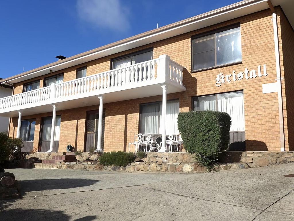 a brick building with a white balcony on it at Top Deck by Kristall Apartments in Jindabyne