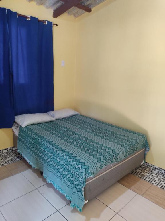 um quarto com uma cama com uma cortina azul em Paraty casa suite em Paraty