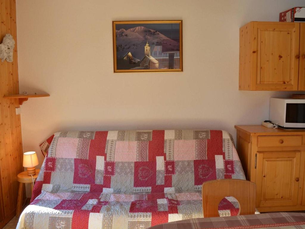 ein Schlafzimmer mit einem Bett mit einer Decke darauf in der Unterkunft Appartement Le Grand-Bornand, 2 pièces, 6 personnes - FR-1-241-188 in Le Grand-Bornand