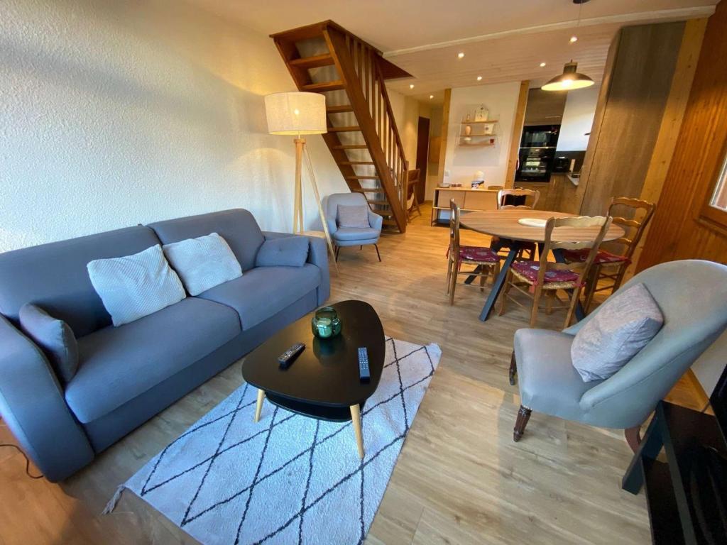 uma sala de estar com um sofá azul e uma mesa em Appartement Le Grand-Bornand, 2 pièces, 6 personnes - FR-1-241-186 em Le Grand-Bornand