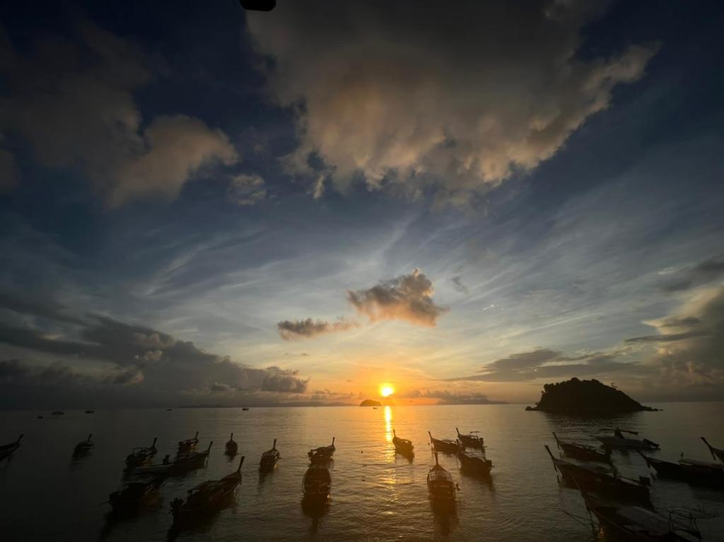a group of people in the water at sunset at Cabana Lipe Beach Resort in Ko Lipe
