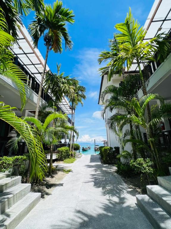 a path between two buildings with palm trees at Cabana Lipe Beach Resort in Ko Lipe
