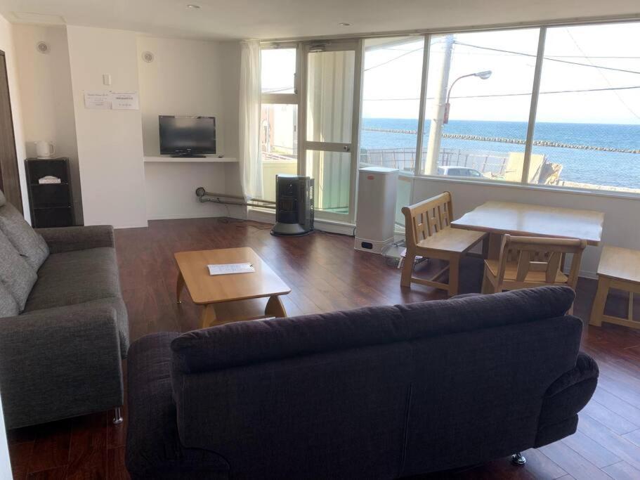 een woonkamer met een bank en een tafel bij Zenibako House 2f in Otaru