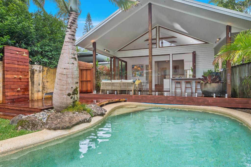 a house with a swimming pool in front of a house at Espadrille Tres in Byron Bay