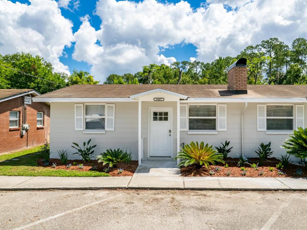 a white house with a blue door at Adorable 2bed1bath Unit Sleeps 4 Close To Town Center Downtown Beach Mayo Clinic in Jacksonville