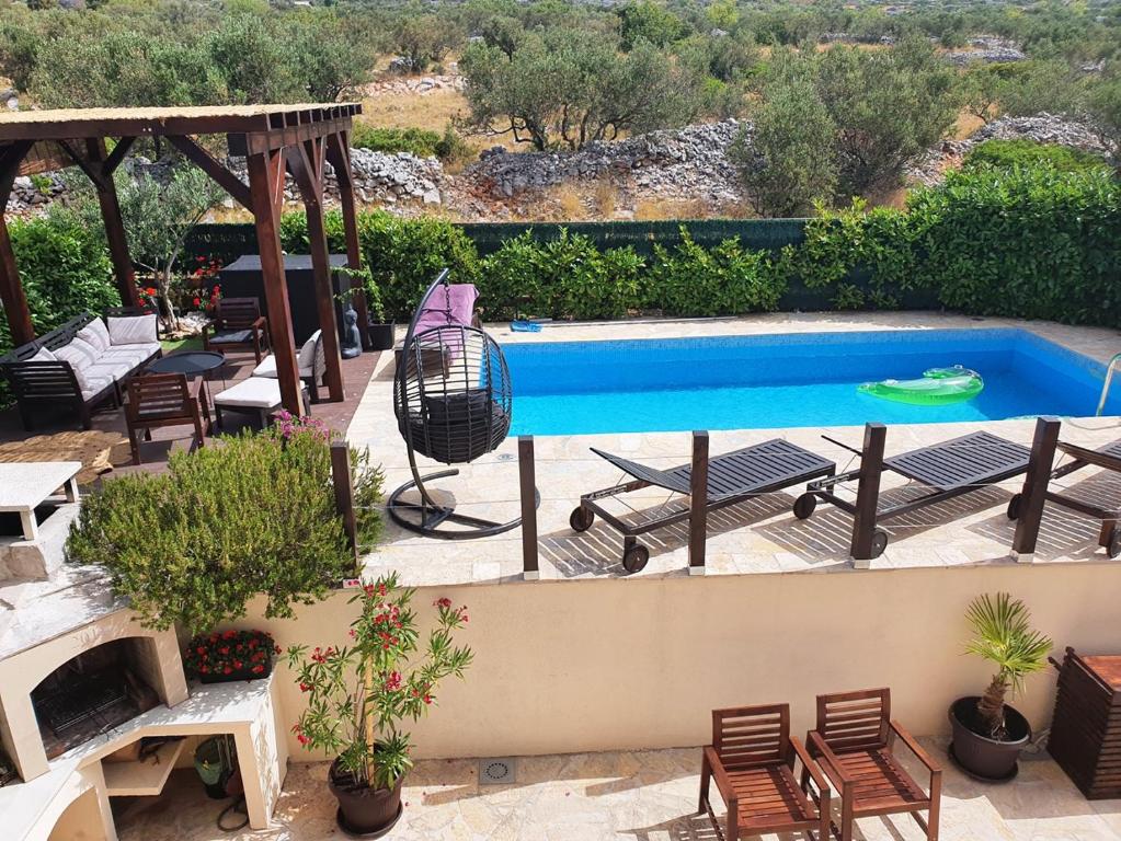 una piscina al aire libre con sillas y una parrilla en Villa Lavandina, en Milna