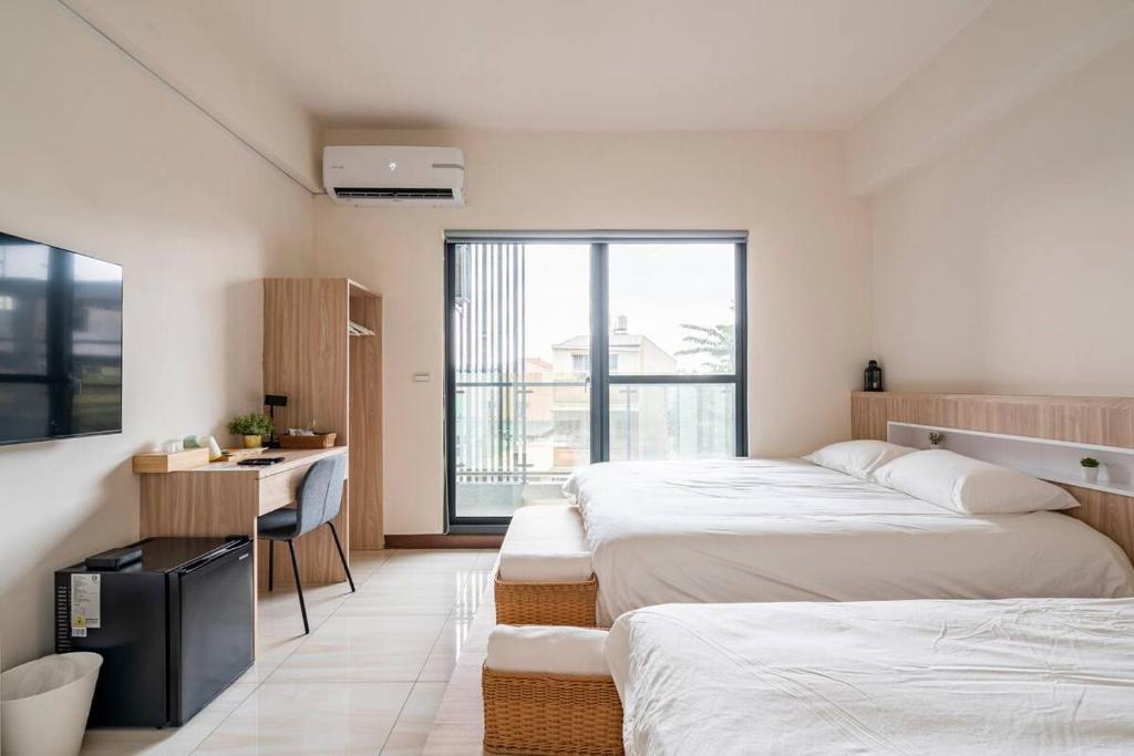 ein Hotelzimmer mit 2 Betten und einem TV in der Unterkunft 余你相寓 in Neipu