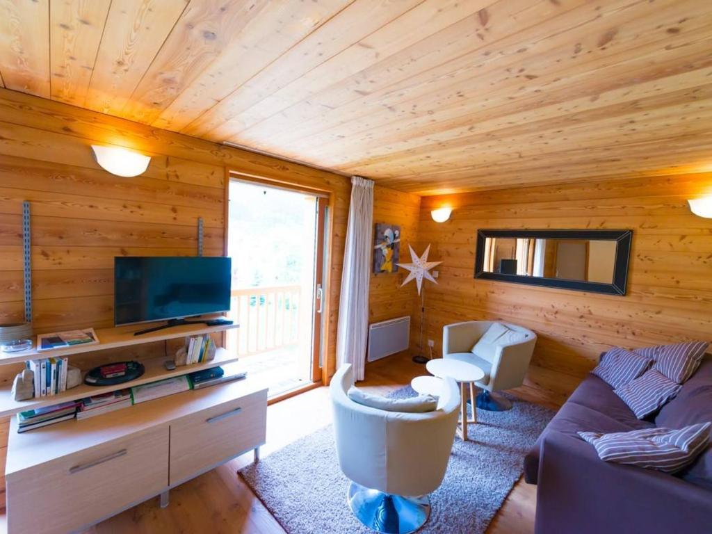 a living room with a couch and a tv at Appartement Le Monêtier-les-Bains, 4 pièces, 6 personnes - FR-1-330F-122 in Le Monêtier-les-Bains