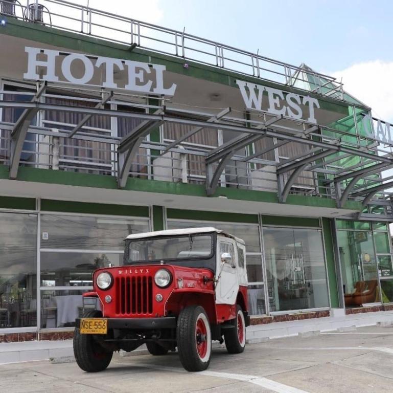 un jeep rojo estacionado frente a un hotel en Hotel West California, en Armenia