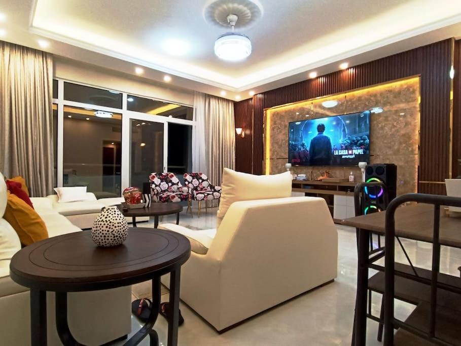 a living room with a couch and a tv at شقة فخمة وواسعة تسع عائلة كبيرة in Ajman 