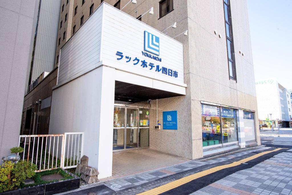 un magasin avec un panneau sur le côté d'un bâtiment dans l'établissement le Lac Hotel Yokkaichi, à Yokkaichi