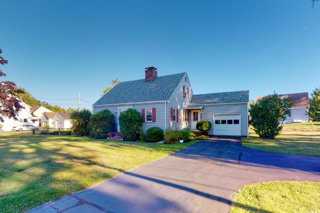 a white house with a driveway in a yard at Montgomery Cottage in Rockland