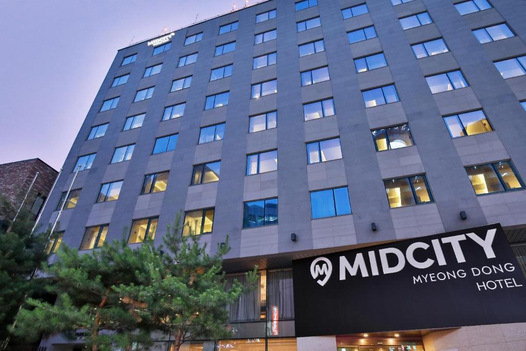 a large building with a sign in front of it at Hotel Midcity Myeongdong in Seoul