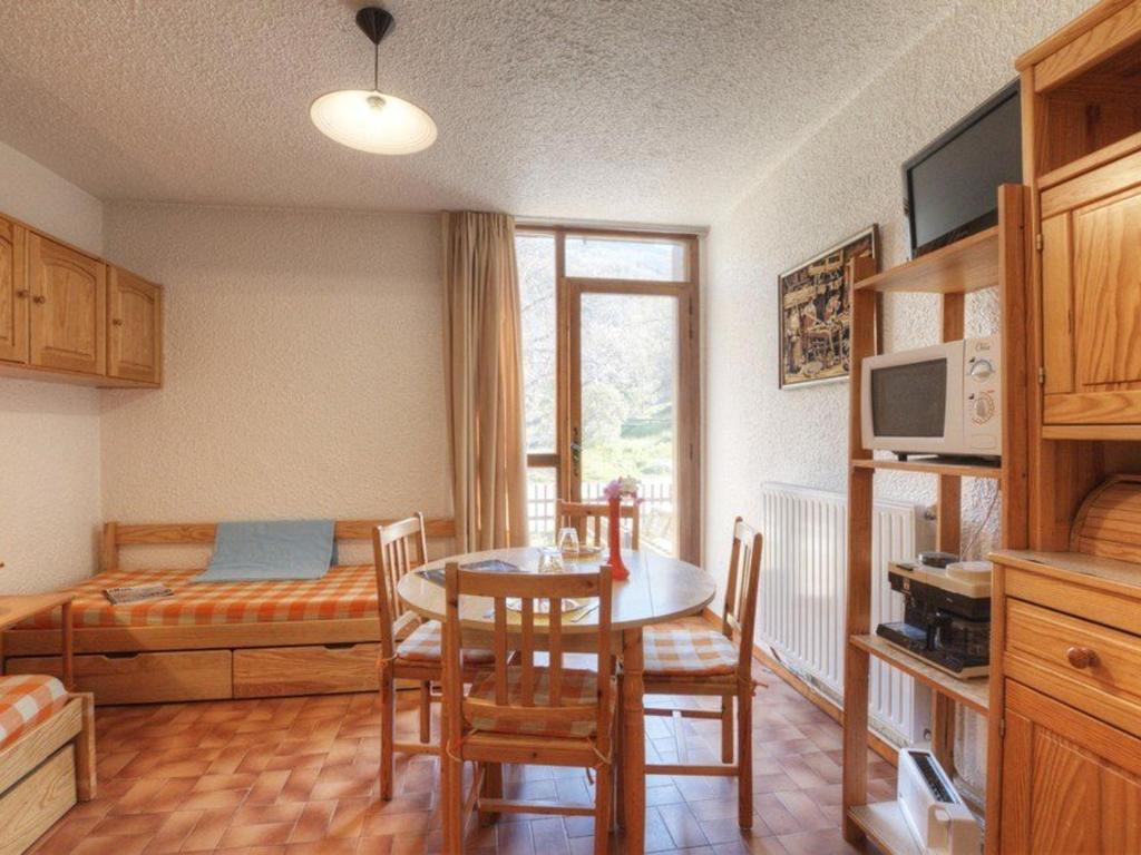 - une cuisine avec une table, des chaises et un lit dans l'établissement Charmant studio tout équipé pour 2 pers, Serre-Chevalier, parking et casier à ski inclus - FR-1-330E-66, à Saint-Chaffrey