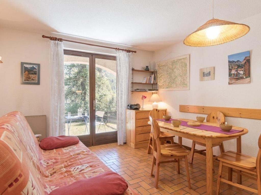 a living room with a table and a couch at Monêtier Les Bains - Appartement 3 pièces avec jardin, rénové, proche Grands Bains - FR-1-330F-75 in Le Monêtier-les-Bains