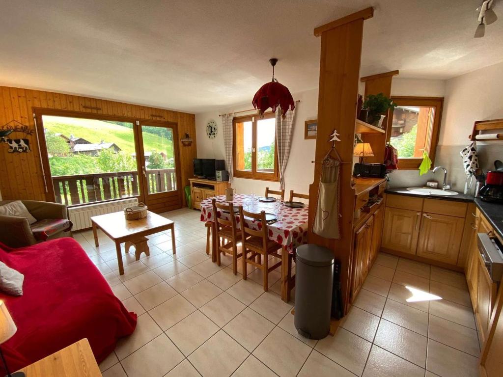 Il comprend une cuisine et un salon avec une table et des chaises. dans l'établissement Appartement Le Grand-Bornand, 3 pièces, 6 personnes - FR-1-241-236, au Grand-Bornand