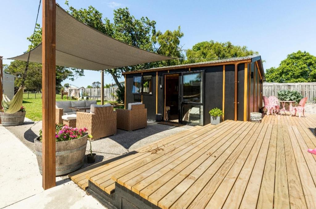 a patio with a wooden deck and a house at Stylish hideaway on High st Carterton in Carterton