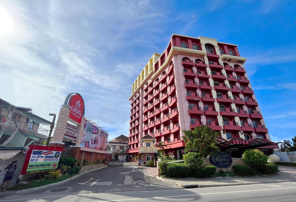 a tall red building on the side of a street at Crown Regency Suites Mactan in Mactan