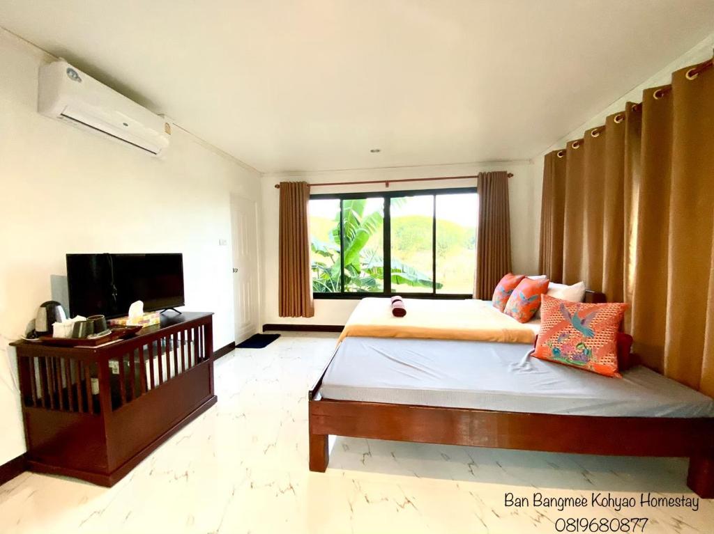 una camera con un grande letto e una televisione di Bang Mee Homestay Koh Yao Noi a Ko Yao Noi
