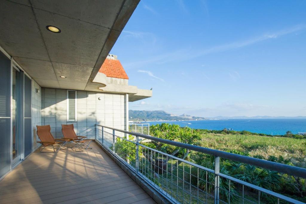Un balcón de una casa con vista al mar. en Sea-k-SEVEN Hotels and Resorts-, en Motobu