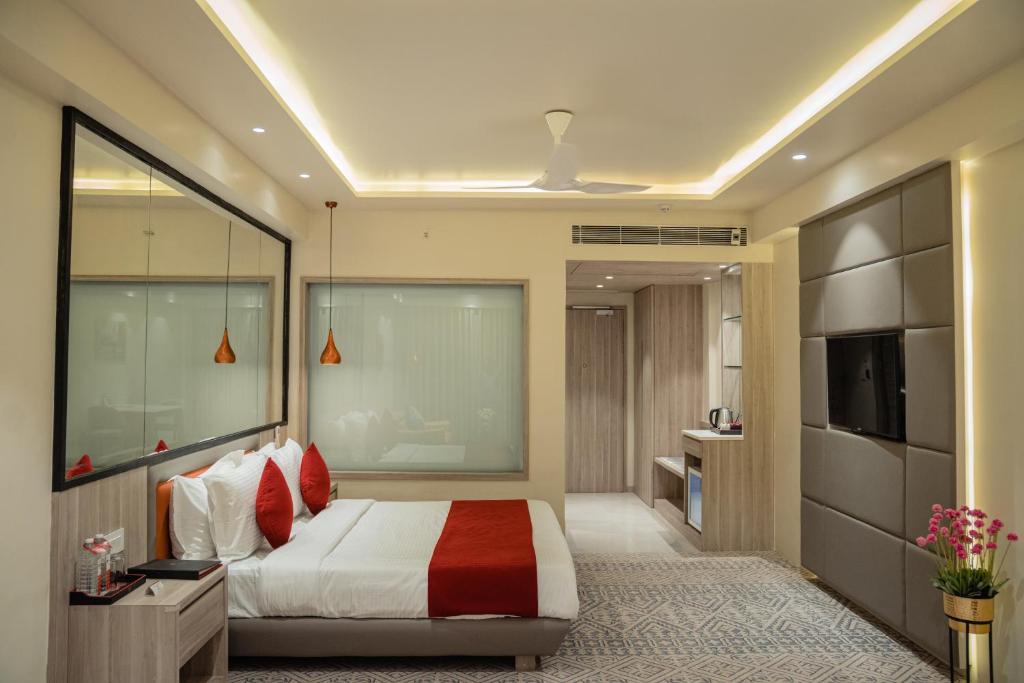 Lords Inn Rajkot في راجكوت: غرفة نوم بسرير كبير وتلفزيون