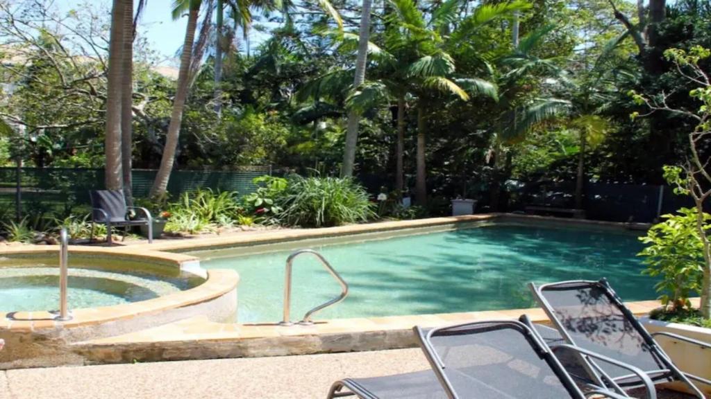 a swimming pool with chairs in front of a resort at Burleigh Terraces - Hosted by Burleigh Letting in Gold Coast